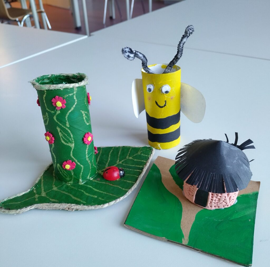 Gebastelte Werke der Kinder aus z.B. Toilettenpapierrollen, wie eine Biene oder bunt bemalte Pflanzen.