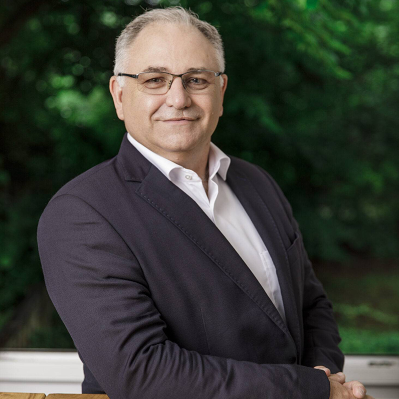 Jörg Angerstein, Vorstand der Hans-Wendt-Stifung, mit freundlichem Gesicht an einem Tisch lehnend