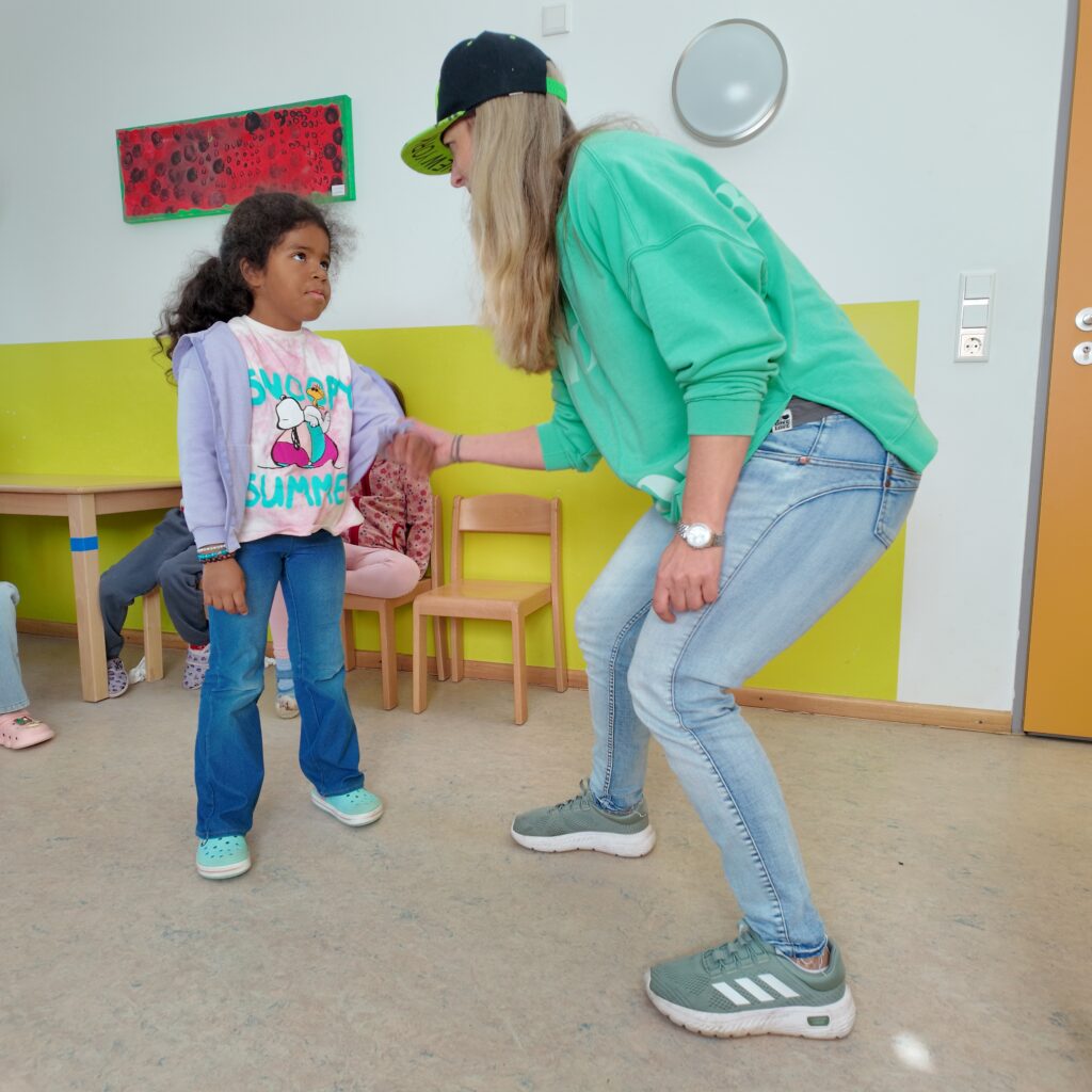 Eine Rollenspielsituation mit der Workshopleiterin in der Rolle der Provozierenden, die ein Mädchen anfasst und böse anschauend anspricht.